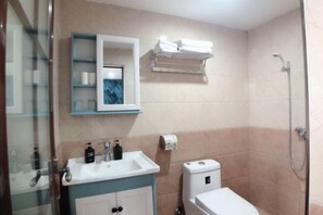 A bathroom with a sink, mirror, toilet, and shower. - AiXi Traving with hostel (Chongqing)
