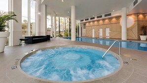 A hot tub area with a pool, indoor seating, and a view of the outdoors. - Apartment M503 - panoramic ocean views for miles! (Scarborough)