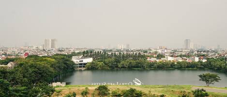 A cityscape with a river, greenery, and buildings in the background.