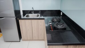 Eine kompakte Küche mit Kühlschrank, Spüle und Gasherd.