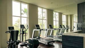 A gym with treadmills, elliptical machines, and a stationary bike. - Minimalist And Comfy 1Br Citralake Suites Apartment (Jakarta)