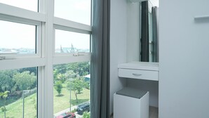 A modern bathroom with a large window, a white sink, and a mirror.