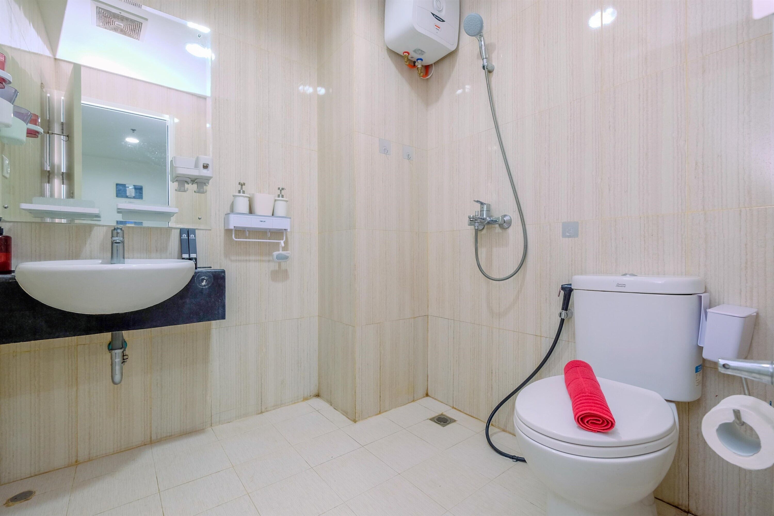 Un baño moderno con lavamanos, espejo, inodoro y ducha.