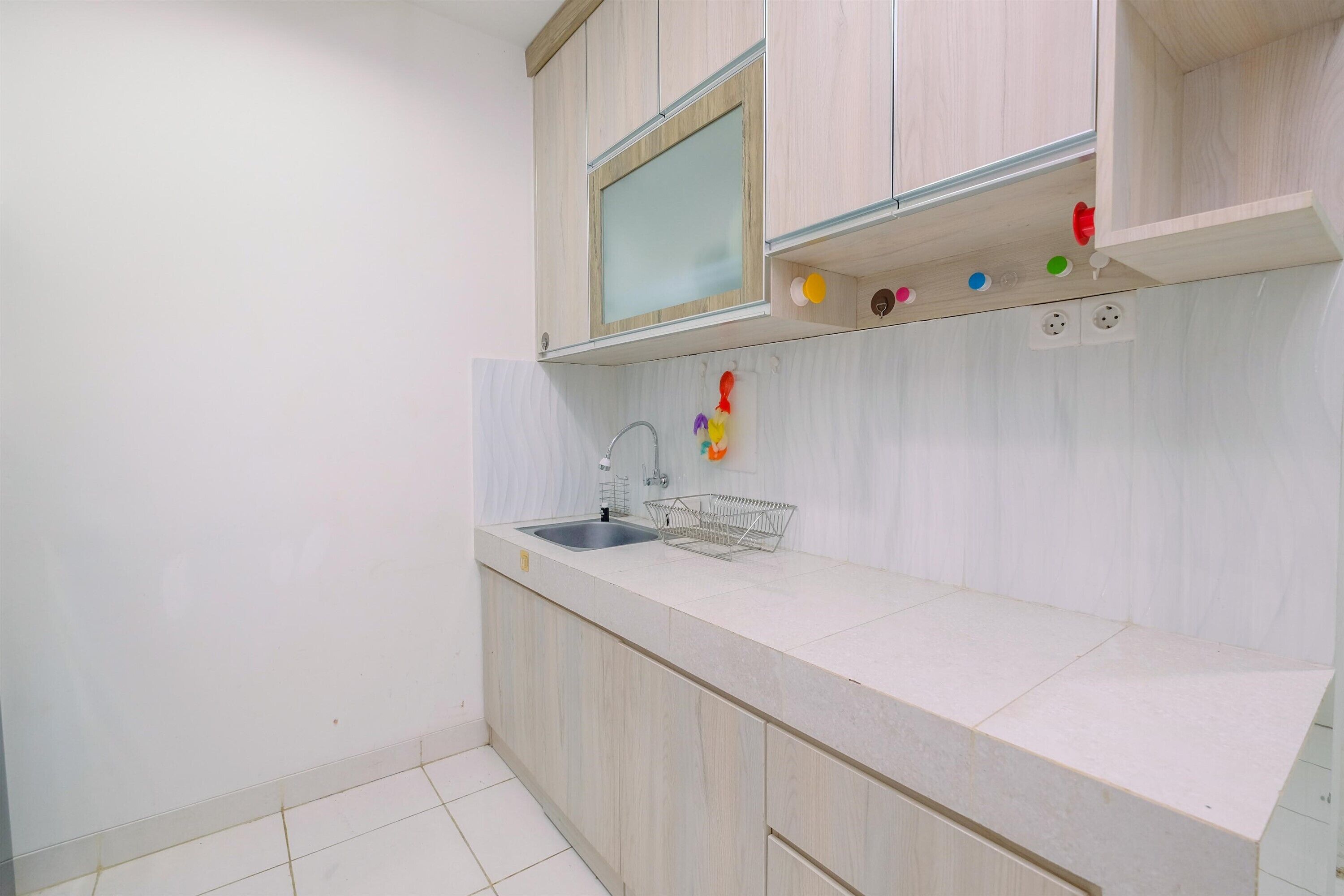 Una cocina con un lavamanos, armarios de madera y una encimera.