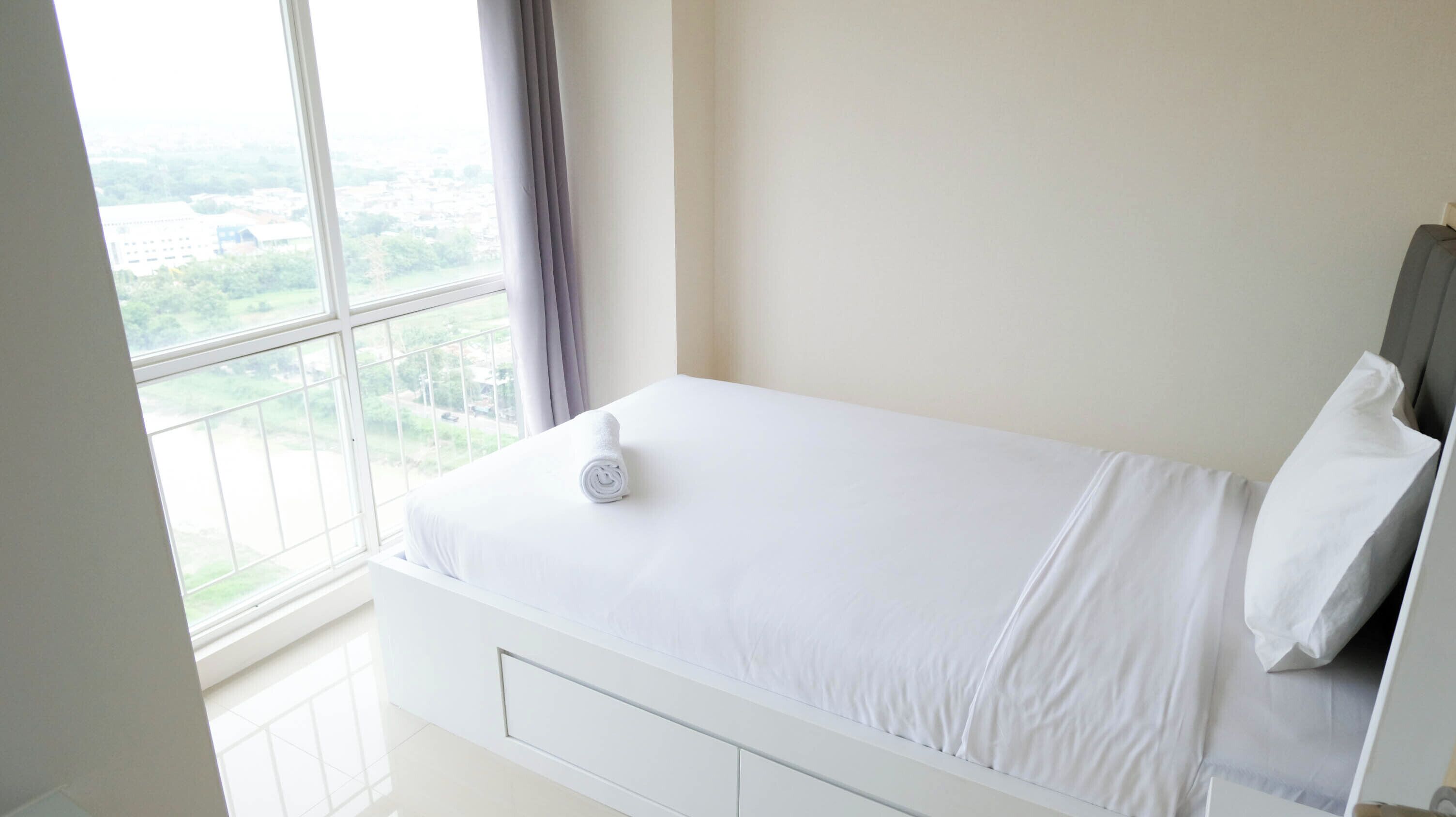 Une chambre à coucher avec un lit, une fenêtre et une vue sur la verdure.