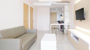 A modern living room with a sofa, a coffee table, and a TV mounted on the wall.