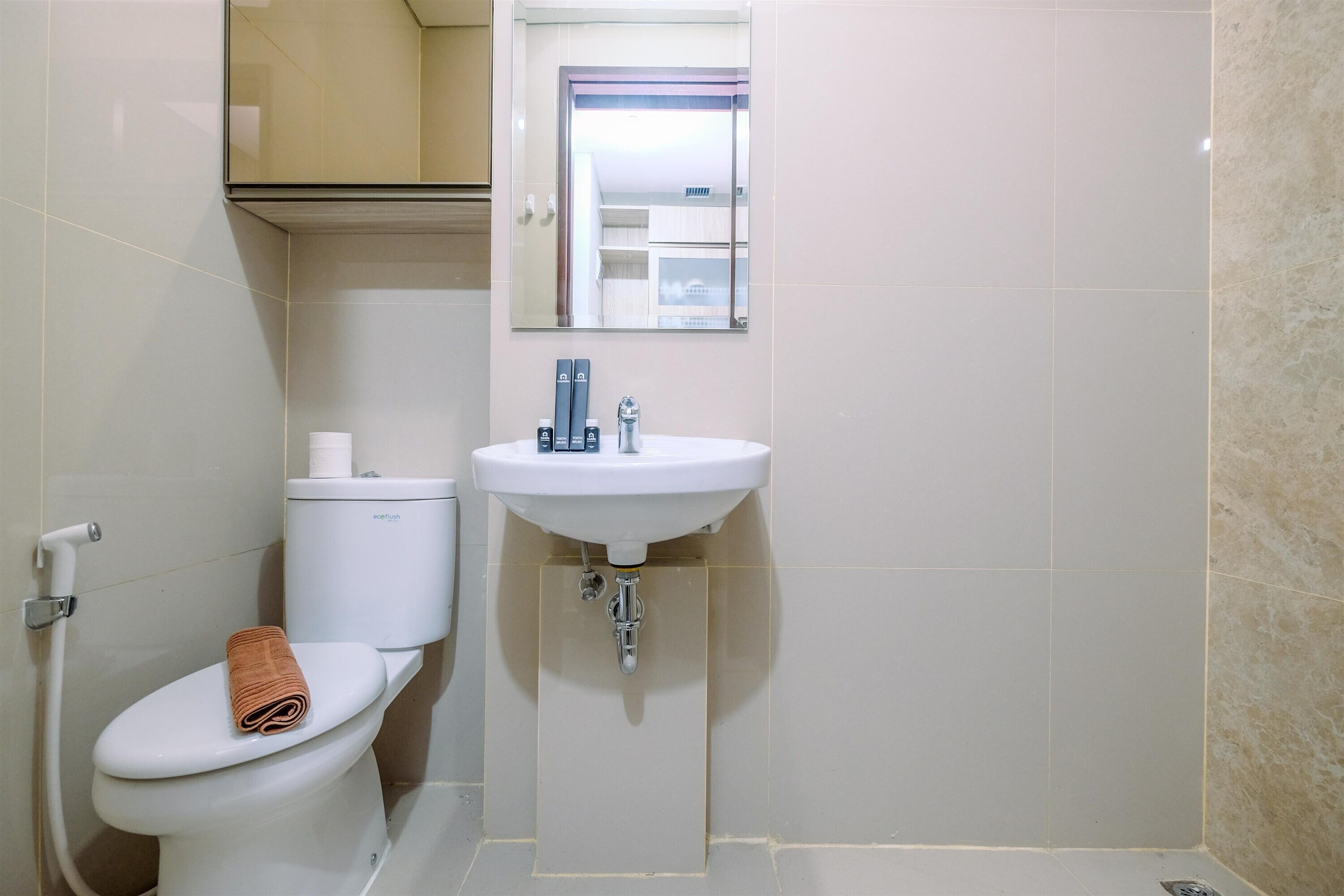 Une salle de bain équipée de toilettes, d’un lavabo et d’un miroir.