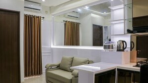 A modern room with a sofa, a coffee machine, and a mirror.