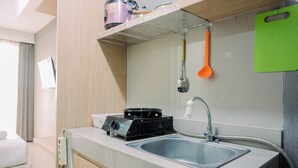 Una cocina moderna con estufa integrada, pileta y tabla de cortar verde.