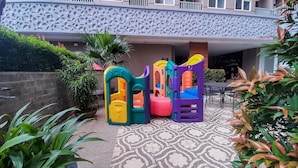 Zona de juegos infantiles con estructuras de escalada coloridas y piso estampado.