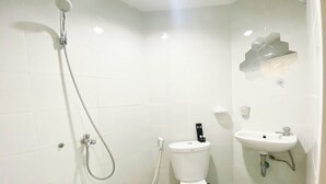 A bathroom with a shower, toilet, and sink. - Homey 1Br Without Living Room At Amartha View Apartment (Semarang)