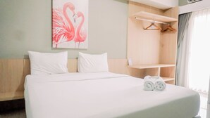 A hotel room with a bed, white pillows, a painting of flamingos, a wooden wardrobe, and a window with curtains. - Comfort 2Br At 3Rd Floor Baileys Apartment (South Tangerang)