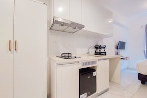 Uma cozinha compacta equipada com forno embutido, micro-ondas e pia.