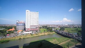 Un immeuble de grande hauteur, sur lequel on peut voir une grande enseigne indiquant « Universitas Diponegoro », et un bâtiment plus petit avec une façade rouge et bleue.