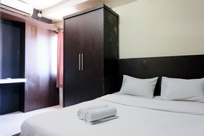 A hotel room with a bed, a wardrobe, and a window with curtains. - Tranquil Designed 2Br At Gateway Ahmad Yani Cicadas Apartment (Bandung)