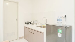 A small kitchenette with a refrigerator, sink, and countertop. - Fancy And Nice 2Br Apartment At Tokyo Riverside Pik 2 (Teluknaga)