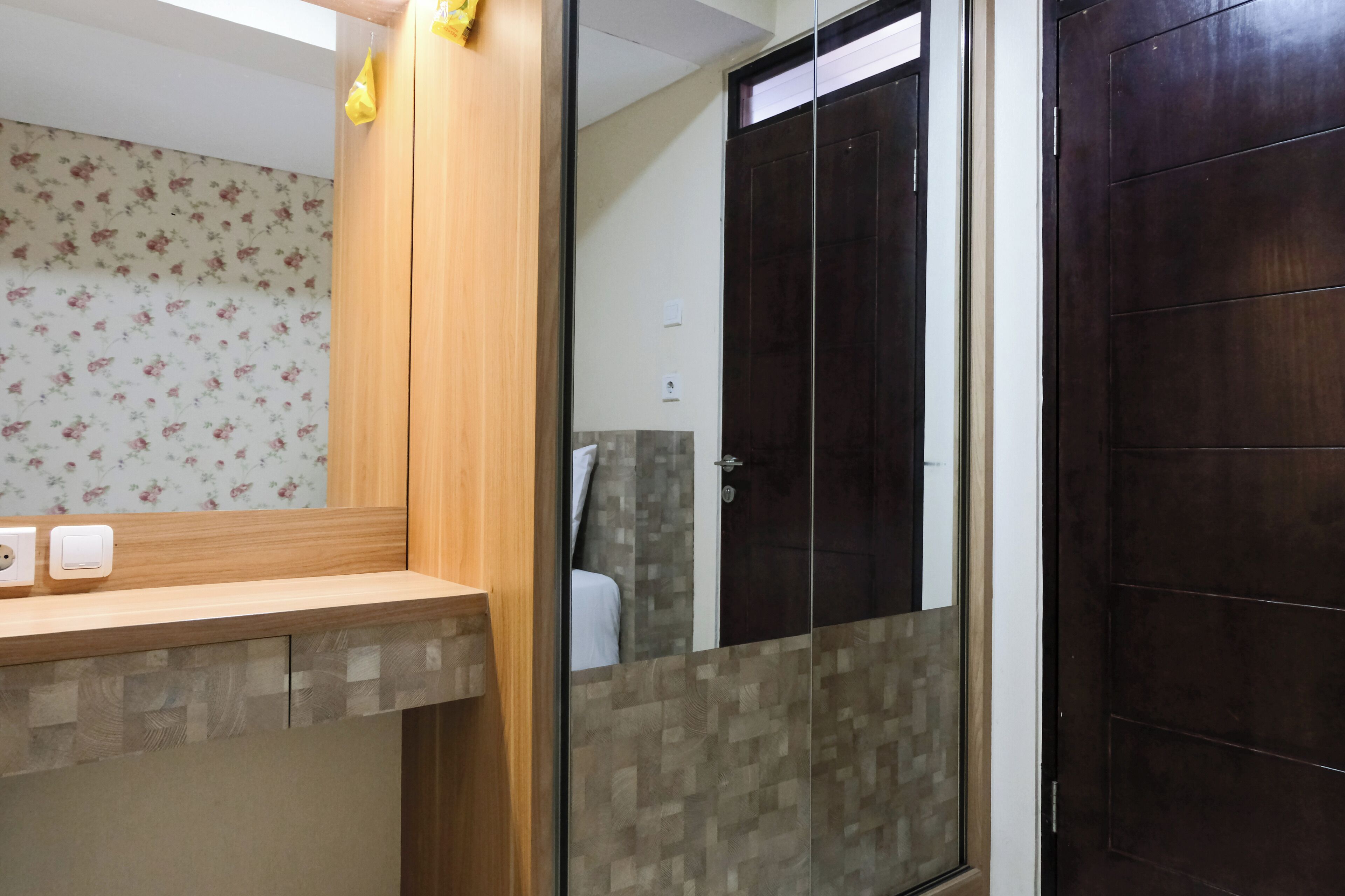 Une salle de bain avec un meuble-lavabo en bois, une cabine de douche en verre et un papier peint à motifs floraux.