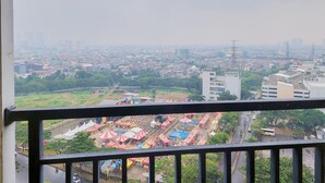 Une vue sur une ville, avec en arrière-plan un espace de fête foraine comprenant des tentes et un autobus.