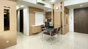 A modern kitchen with a built-in stove, a clock, and a whiteboard on the wall. - Modern Look And Comfort 2Br Kemang Village Apartment (Jakarta)