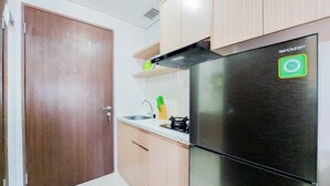 Une cuisine équipée d’un réfrigérateur en acier inoxydable, de meubles de rangement en bois, d’un évier et d’une cuisinière.