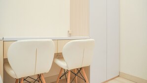 Une pièce au décor minimaliste, avec deux chaises blanches et un bureau blanc.