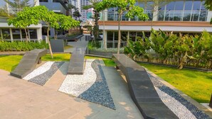 A modern outdoor area with a pathway, benches, and greenery.