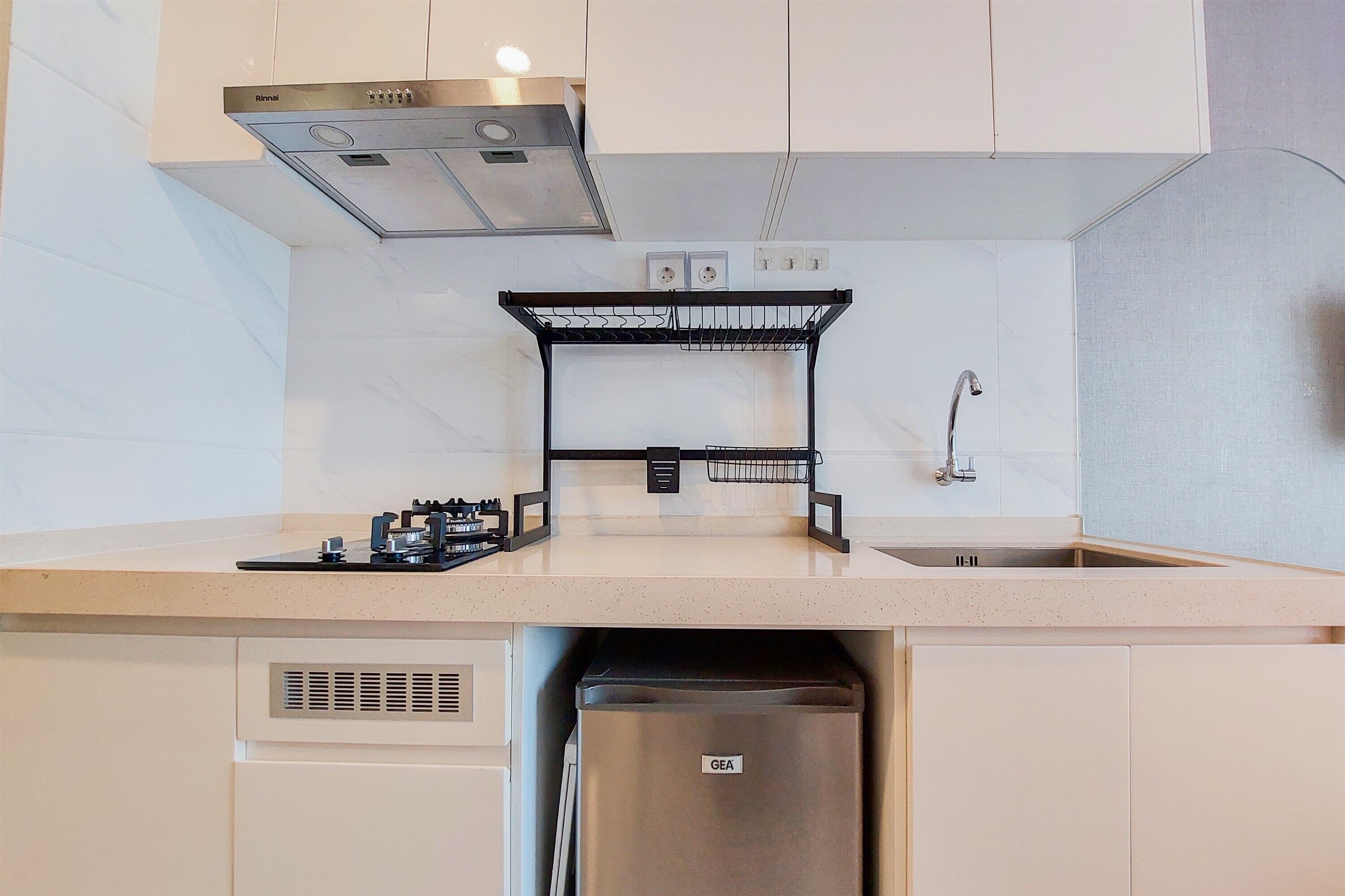 A modern kitchen with a stainless steel refrigerator, a gas stove, and a built-in oven.