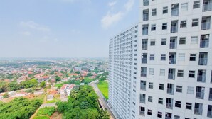 A high-rise building with multiple floors, large windows, and balconies. - Gorgeous And Homey 2Br Serpong Garden Apartment (Cisauk)
