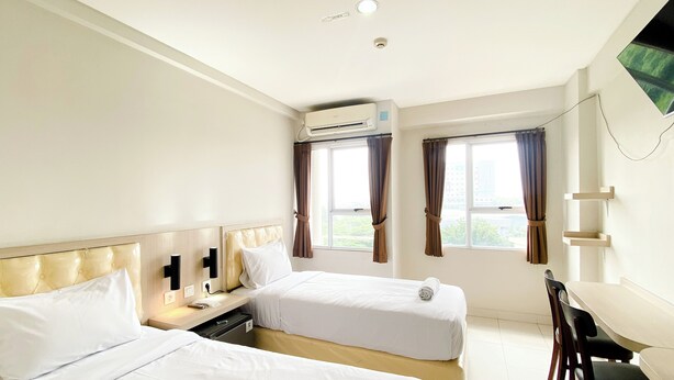 Une chambre d’hôtel avec deux lits, un bureau et une chaise.