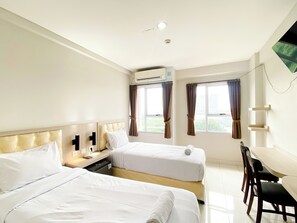 A hotel room with two beds, a desk, and a chair. - Cozy Stay Studio Apartment (No Kitchen) At Elvis Tower (Cikarang)