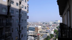 Ein Hochhaus mit mehreren Balkonen und Blick auf eine Stadtlandschaft.