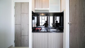 Una cocina compacta con estufa integrada, un lavamanos y armarios de madera.