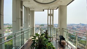 Un edificio de gran altura con balcón de cristal, que ofrece vistas a la ciudad.