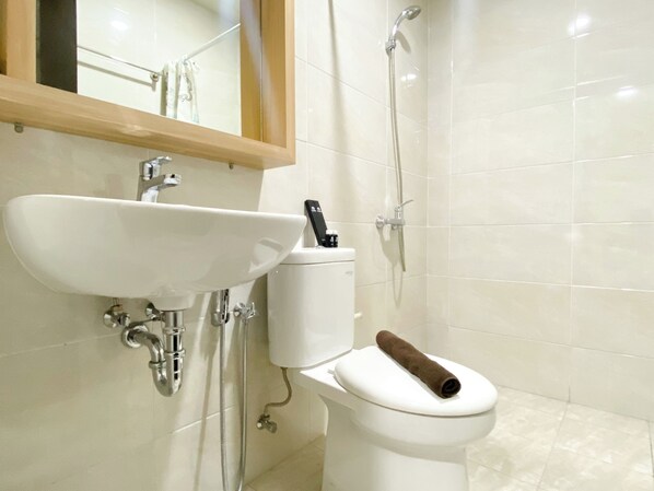 A bathroom with a white sink, toilet, and shower. - Stunning And Homey 2Br Apartment Mustika Golf Residence (Cikarang)