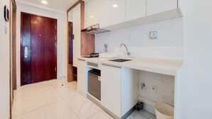 Una cocina moderna con armarios blancos, un lavamanos de acero inoxidable y un lavavajillas integrado.