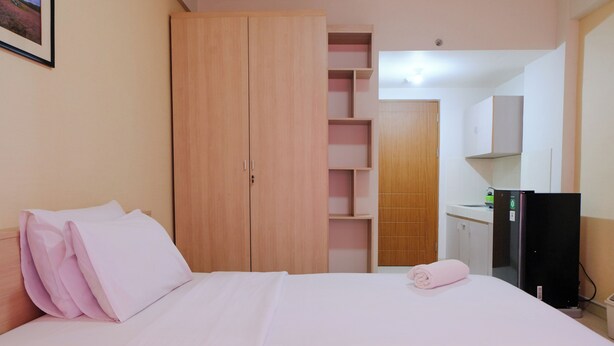Una habitación de hotel con cama, armario, escritorio y televisor.