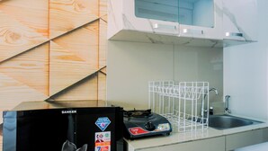 Una cocina con estufa a gas, un lavaplatos y una rejilla metálica blanca.
