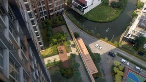 Un immeuble de grande hauteur, doté de nombreux étages, avec une rivière qui le longe et un terrain de basketball.