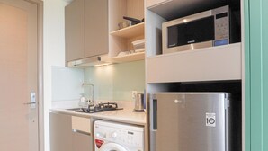 Une cuisine compacte équipée d’un lave-linge, d’un four à micro-ondes et d’un réfrigérateur.