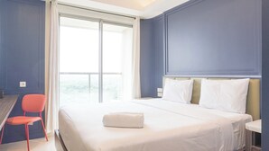 Une chambre d’hôtel avec un grand lit, un bureau et une chaise.