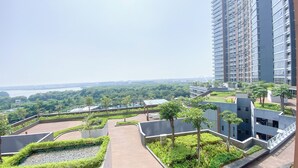 Un immeuble résidentiel de grande hauteur doté d’un jardin sur le toit, d’une piscine et offrant une vue sur une rivière.