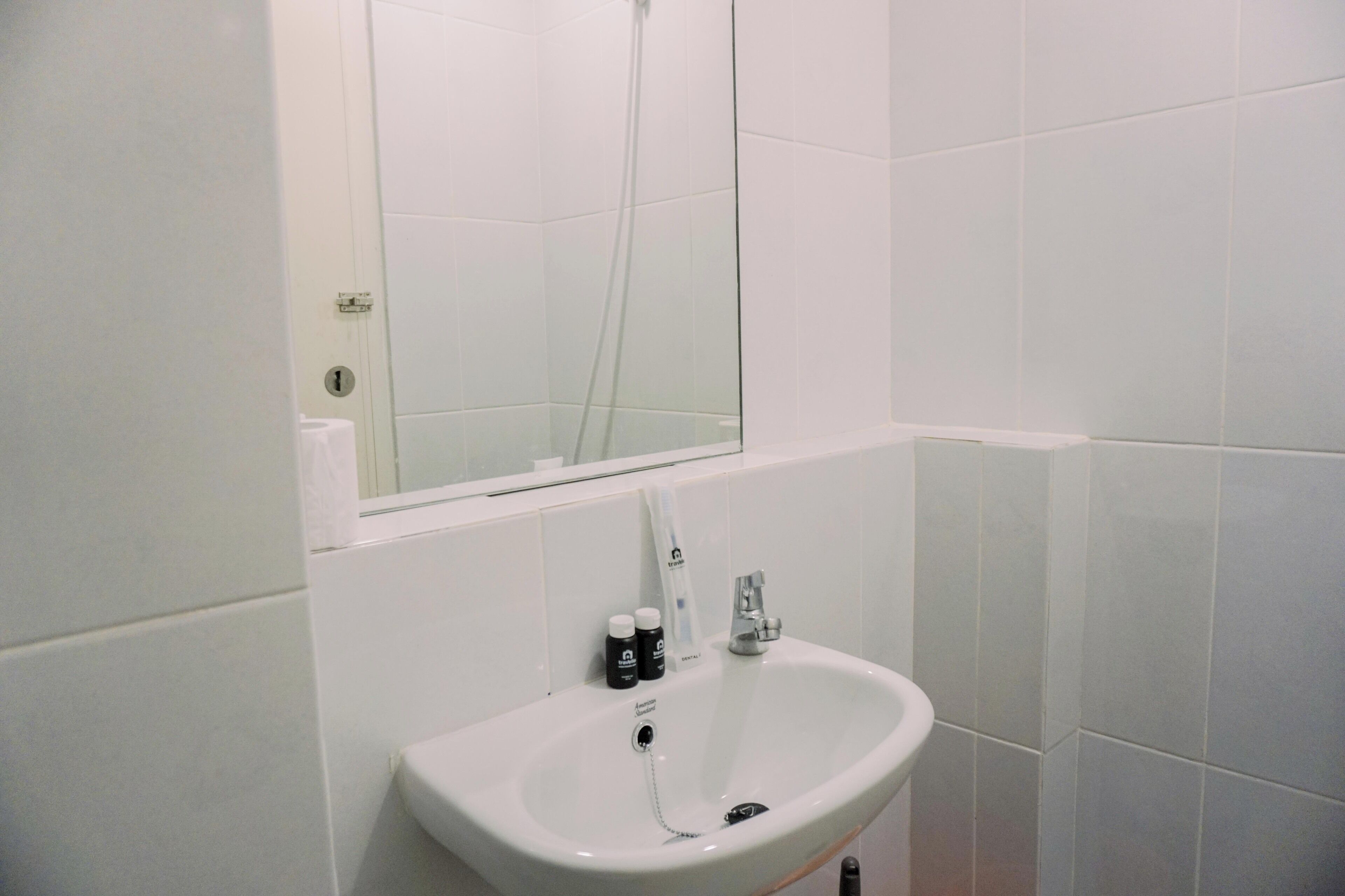 A bathroom with a white sink, a mirror, and a shower.