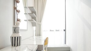 A modern kitchen with a marble countertop, a striped vase, and a chair with a yellow leaf design. - Gorgeous And Comfortable 1Br Sudirman Suites Apartment (Jakarta)