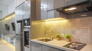 A modern kitchen with stainless steel appliances, a built-in oven, and a sink. - Gorgeous And Comfortable 1Br Sudirman Suites Apartment (Jakarta)