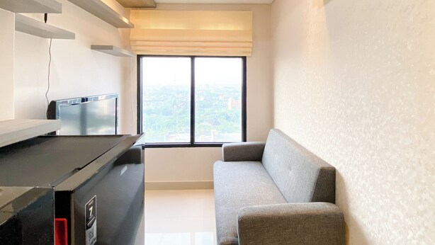A modern kitchen with a built-in stove, a black countertop, and a window with a city view. - Cozy And Comfort 2Br At Pollux Chadstone Apartment (Cikarang)