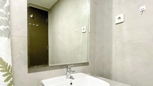 A modern bathroom with a white sink, a mirror, and a towel rack. - Cozy And Comfort 2Br At Pollux Chadstone Apartment (Cikarang)