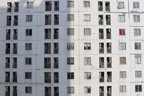A multi-story building with numerous windows, some with balconies.