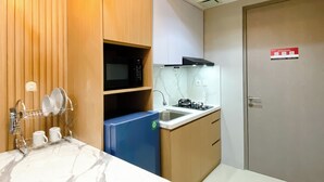 Une cuisine compacte équipée d’un four à micro-ondes, d’une cuisinière et d’un égouttoir à vaisselle.
