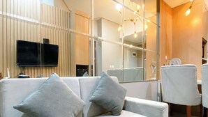 Un salon moderne avec un canapé, un téléviseur et un coin repas.
