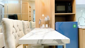 Une cuisine moderne avec un plan de travail en marbre, un réfrigérateur bleu et des armoires en bois.